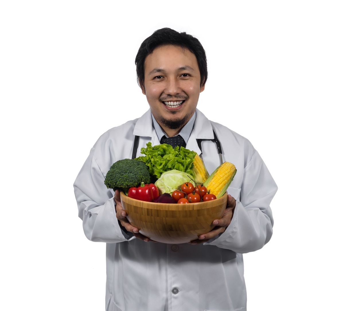Portrait of asian doctor holding the mix fresh vegetables in wooden bowl with exciting action on white background, Healthy food concept.